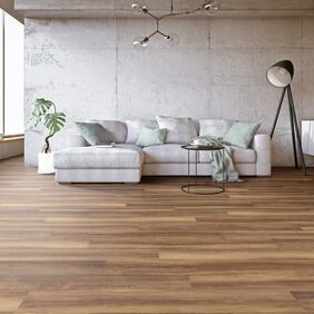 Wood effect flooring laid in a large open area with a light coloured couch