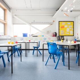 Light blue flooring in a classroom with table and chairs