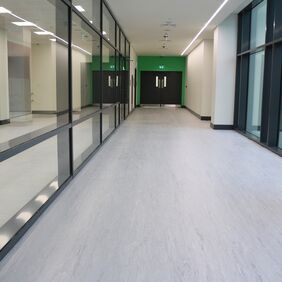 Light grey homogeneous flooring in a commercial corridor 