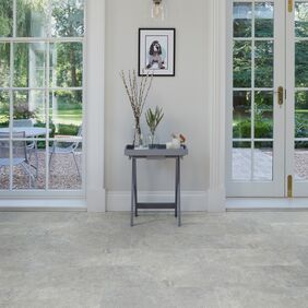 Side table, large framed windows, picture, cement style tile floor 