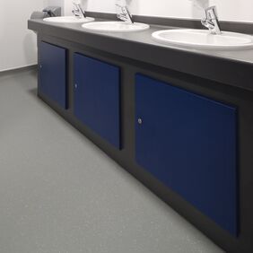 Grey safety flooring in a public bathroom sink area