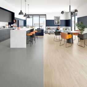 Grey stone and light oak wood effect flooring in a large open plan kitchen