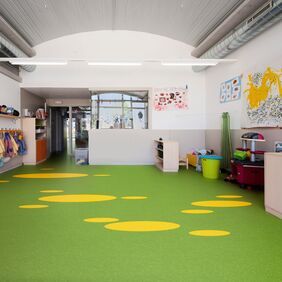 Green flooring with yellow circles in a nursery play room