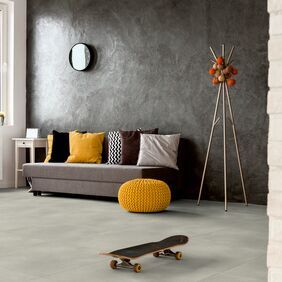 Grey concrete effect flooring in a living room with a grey sofa and accessories 