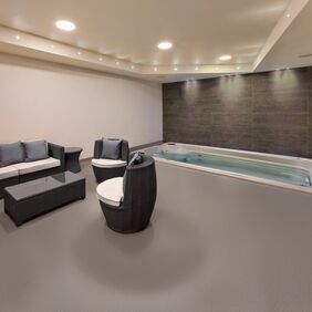 Brown colour safety flooring in a spa relaxation area with seating and hot tub