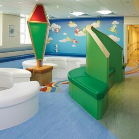 Light blue homogeneous flooring with a rainbow motif design in the flooring in a childrens hospial waiting area