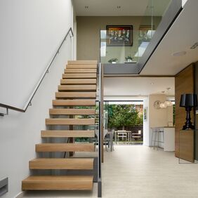 Wooded Staircase featuring stone effect flooring laid in a brickwork design 