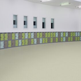 Neutral colour safety flooring in a large open space with lockers 