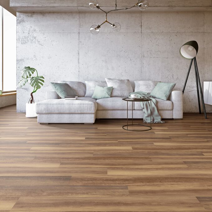 Wood effect flooring laid in a large open area with a light coloured couch