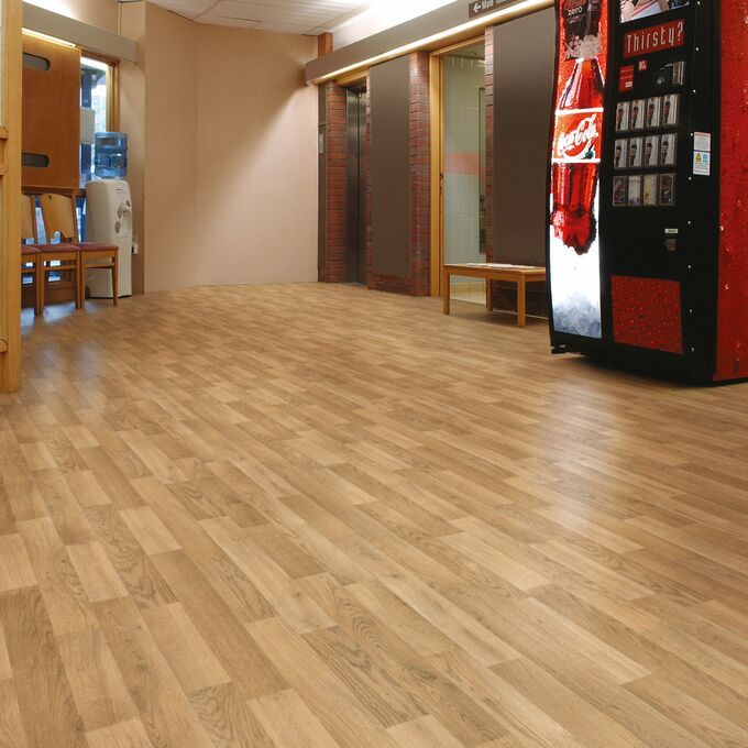 Light brown rustic oak effect flooring in a corridor with vending machinem and seat area