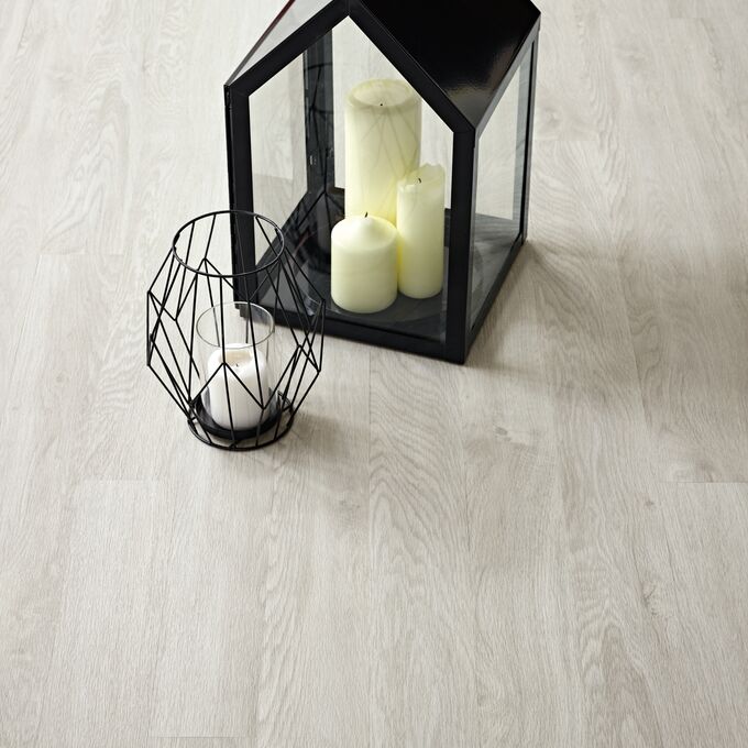 Close up of Bianco Oak ligh wood effect flooring with glass lantern and candle