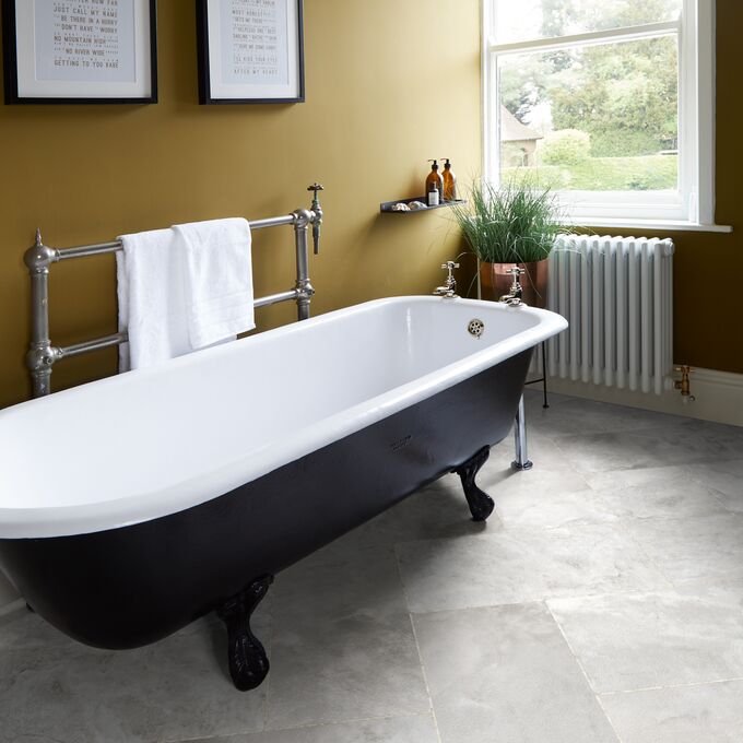 Grey coloured slate effect flooring laid in a bathroom with a roll top bath