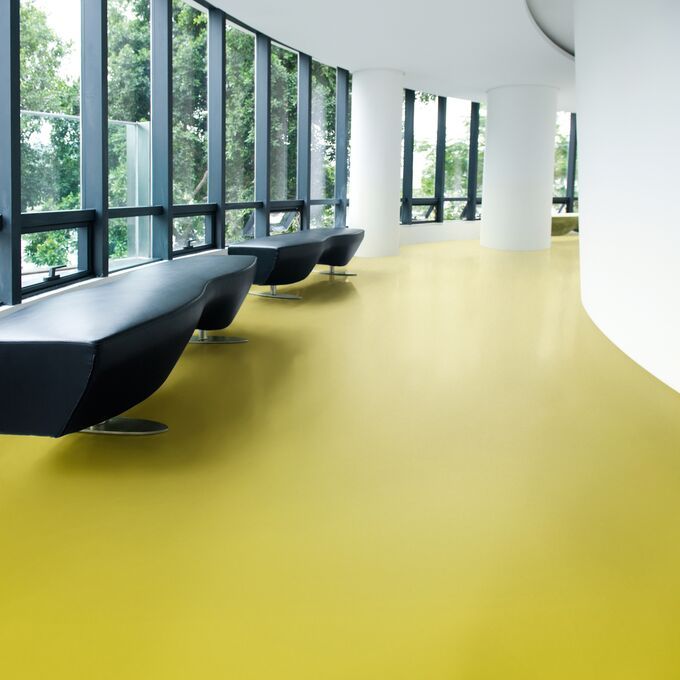 Modern waiting area with green flooring and black seating