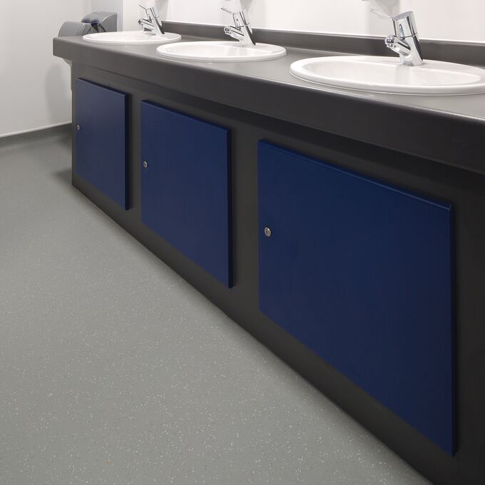 Grey safety flooring in a public bathroom sink area