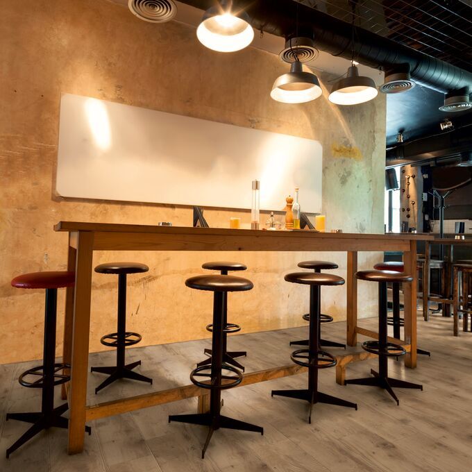 Oak effect flooring laid in a bar area with high table and stools