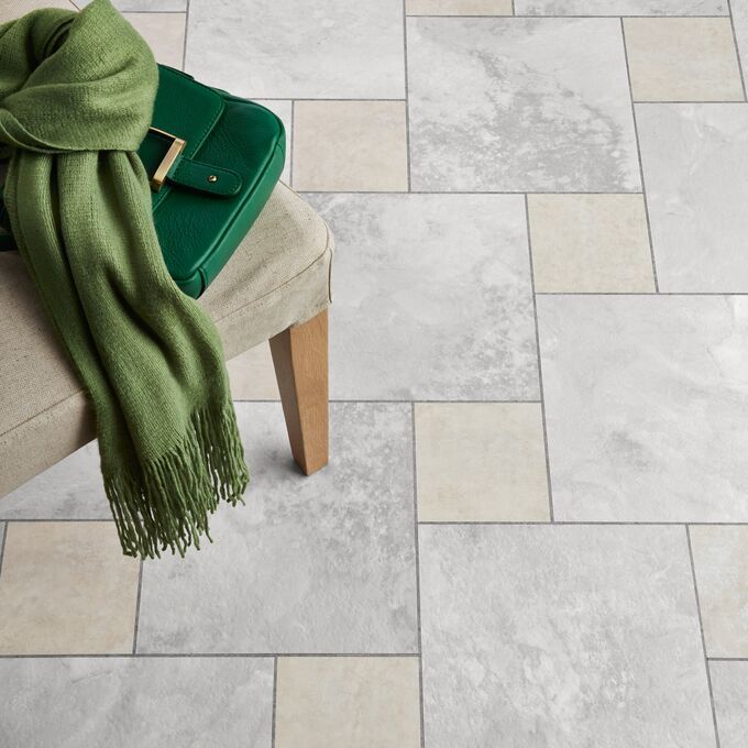 Close up of stone effect flooring laid in a Off-set keysquare design, alongside White Metalstone with Grey Grouting Strip.