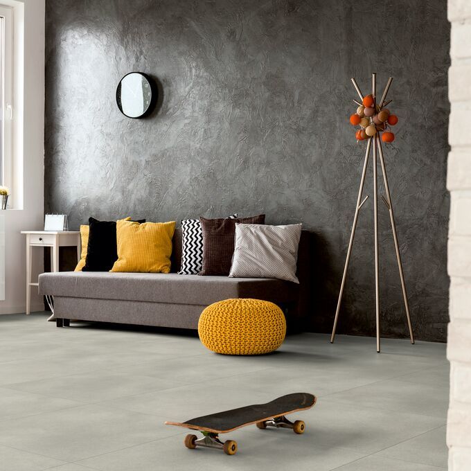 Grey concrete effect flooring in a living room with a grey sofa and accessories 