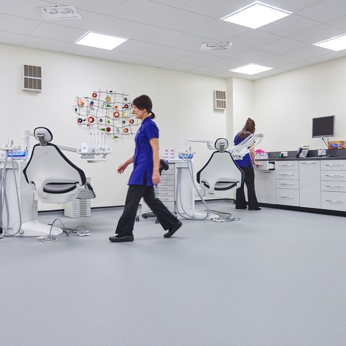 Light blue safety flooring in a Dentist room with chairs and dental nurses