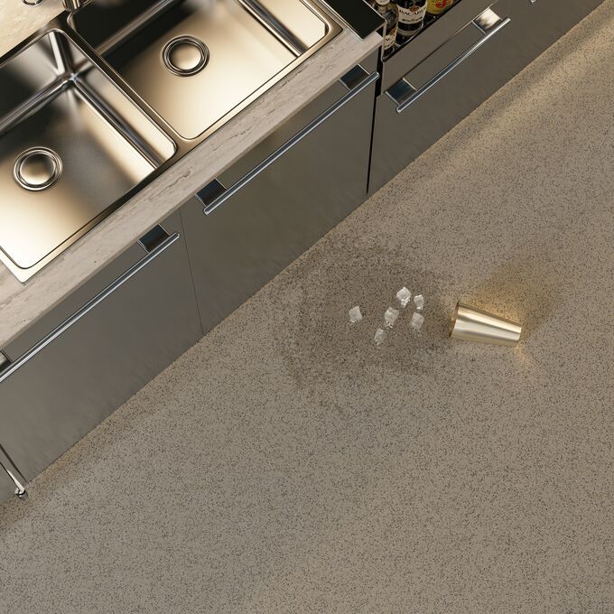 Overhead shot of a commercial kitchen with a spilled drink on the dark coloured floor