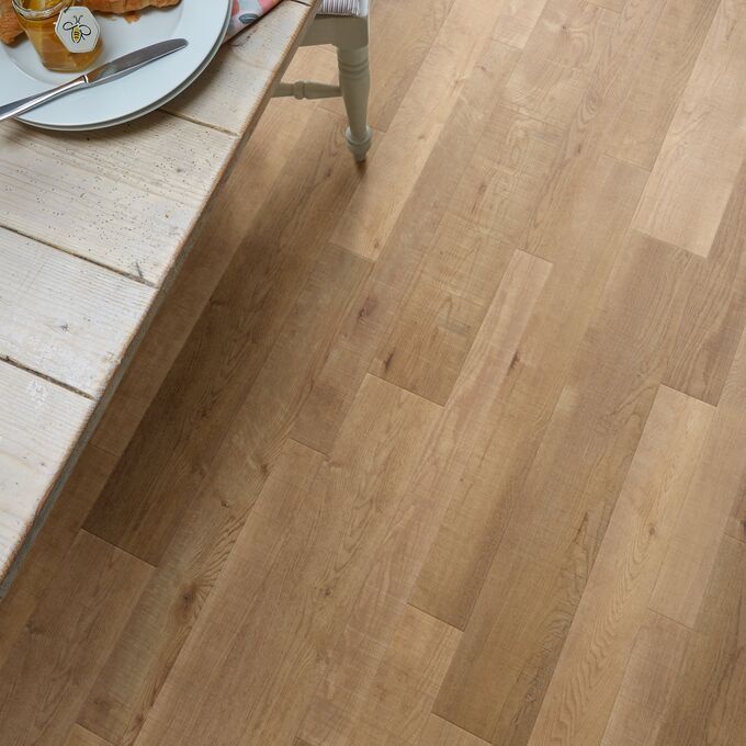 Close up of dining table and chair featuring light timber wood effect flooring in Salvaged Timber 